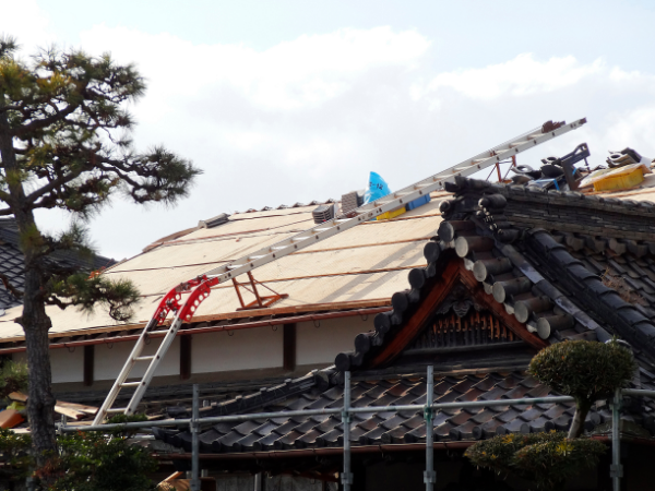 屋根葺き替えの作業を行う作業員